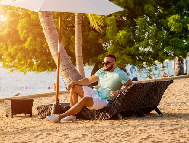 Jeune homme sur une plage tropicale.