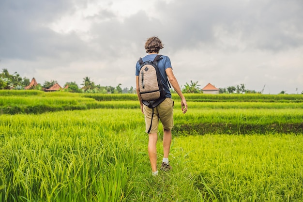 Jeune homme sur la plantation de rizière en cascade verte. Bali, Indonésie.