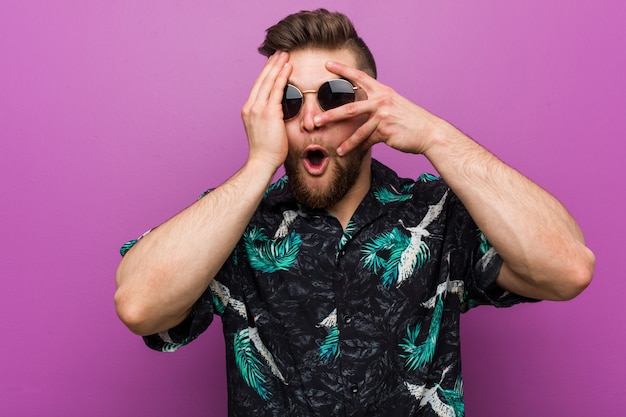 Un jeune homme portant un air de vacances clignote des doigts effrayés et nerveux.