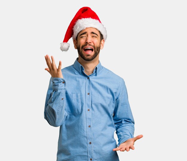 Jeune homme portant le bonnet de Noel très effrayé