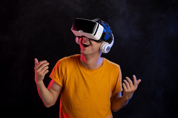 Jeune homme portant un casque de réalité virtuelle sur la surface sombre