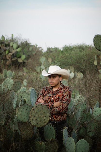 Jeune homme portant un chapeau de cow-boy et tenant un cactus