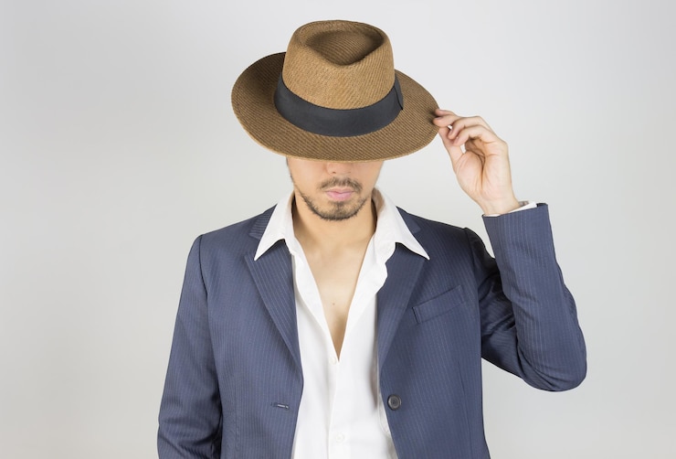 Photo un jeune homme portant un chapeau debout sur un fond blanc