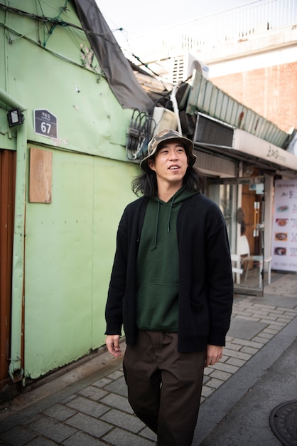 Photo jeune homme portant un chapeau de seau dans la ville