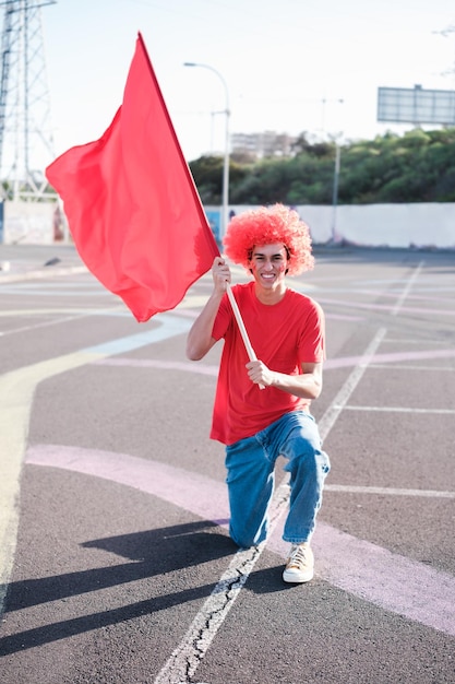 Jeune homme portant un drapeau pour soutenir son équipe et devenir un fan spécial pour son équipe Concept fans équipes sportives