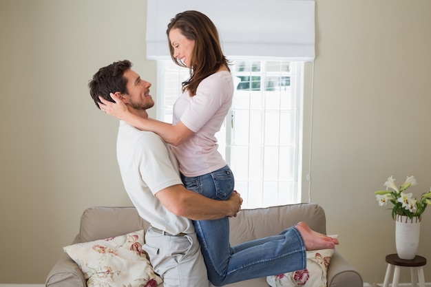 Jeune homme portant la femme à la maison