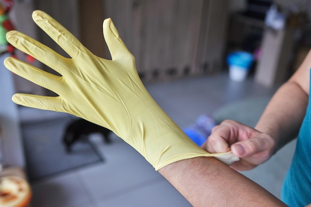 Jeune homme portant des gants en caoutchouc jaune prêt à nettoyer