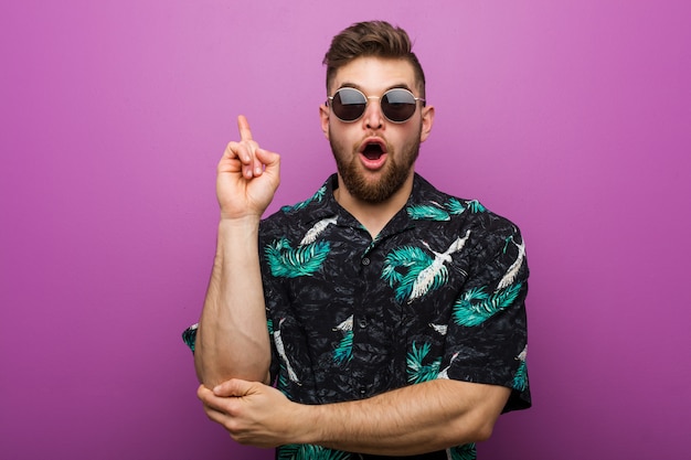 Jeune homme portant un look de vacances ayant une bonne idée