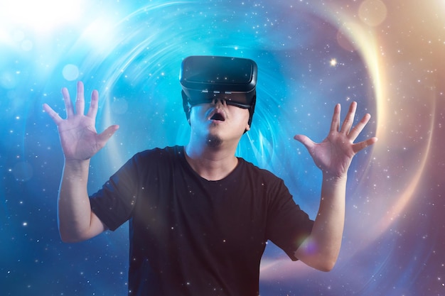 Le jeune homme portant des lunettes de réalité virtuelle avec un incroyable arrière-plan d'imagerie virtuelle de l'espace futuriste cosmique