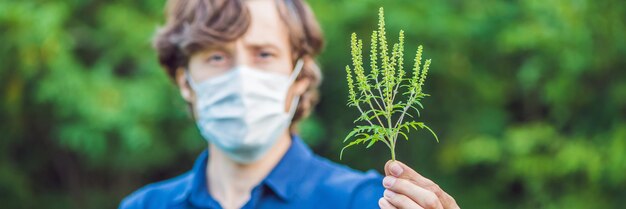 Photo jeune homme portant un masque médical à cause d'une allergie au format long de la bannière de l'herbe à poux