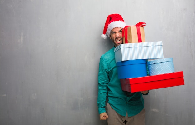 Jeune homme, porter, noël, chapeau, tenue, cadeaux, crier, très, colère, agressif