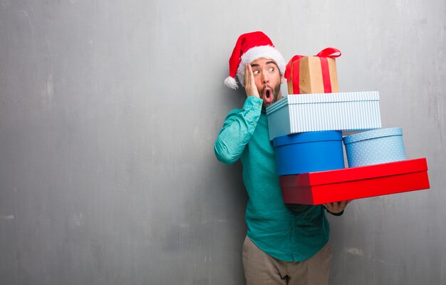 Jeune homme, porter, noël, chapeau, tenue, cadeaux, surpris, choqué