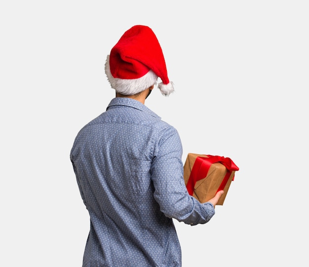 Jeune homme, porter, santa hat, par-derrière, regarder dos