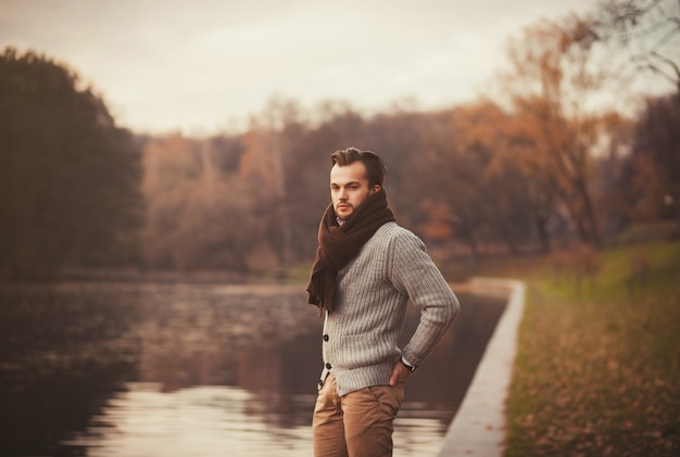 Jeune homme posant dans le parc en automne