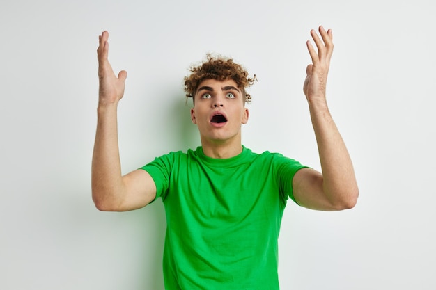 Jeune homme posant sur un fond blanc dans un t-shirt vert