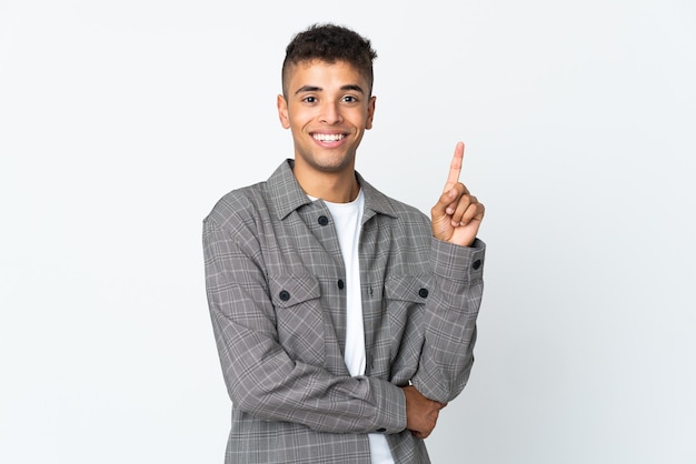 Jeune homme posant isolé contre le mur blanc