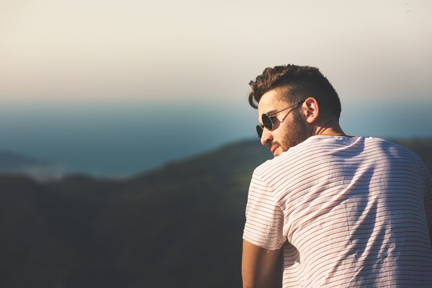 Jeune homme posant pour une photo dans les montagnes.