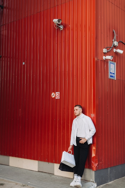 Jeune homme posant avec des sacs à provisions le vendredi noir