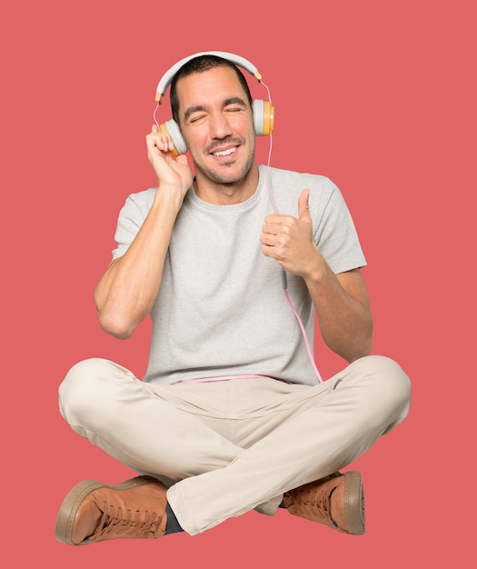 Jeune homme en position assise avec un geste de doute