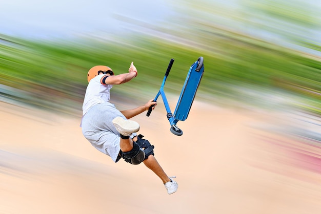 Photo un jeune homme pratiquant le scootering freestyle au skatepark d'igualada à barcelone. arrière-plan flou.