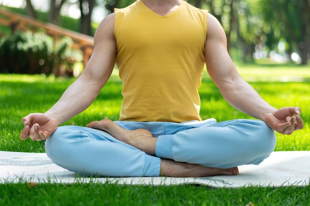 Jeune homme pratique le yoga dans le parc Asanas de yoga dans le parc de la ville journée ensoleillée Concept de bien-être méditatif et mode de vie sain