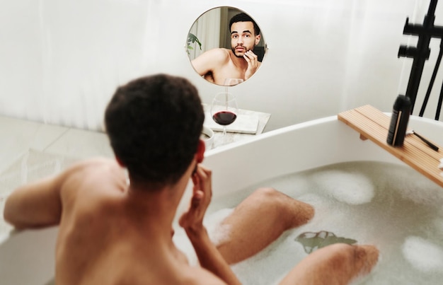 Jeune homme prenant un bain dans la salle de bain