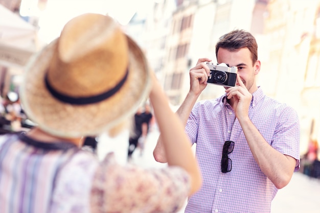 Jeune homme prenant une photo de sa petite amie tout en visitant Gdansk en Pologne