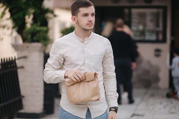 Un jeune homme prend des aliments frais à partir d'un café végétalien en plein air