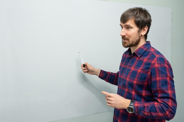 Jeune homme préparant une présentation sur un tableau blanc au bureau Concept d'idée d'entreprise