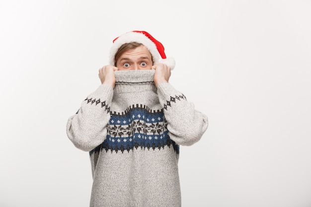 Jeune homme en pull profiter de jouer avec Bonnet de Noel.