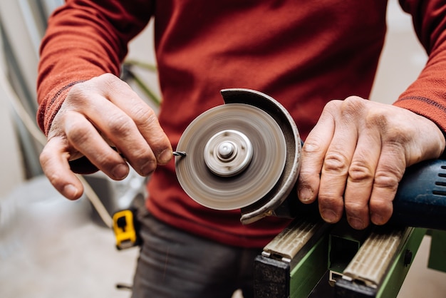 Jeune homme avec un pull rouge faisant quelque chose avec des outils industriels