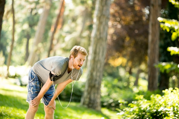 Jeune homme qui court dans le parc en automne