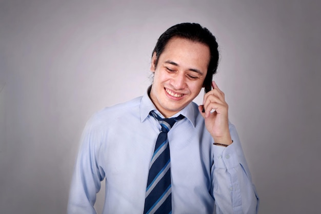 Un jeune homme qui parle au téléphone, heureux, souriant, riant.