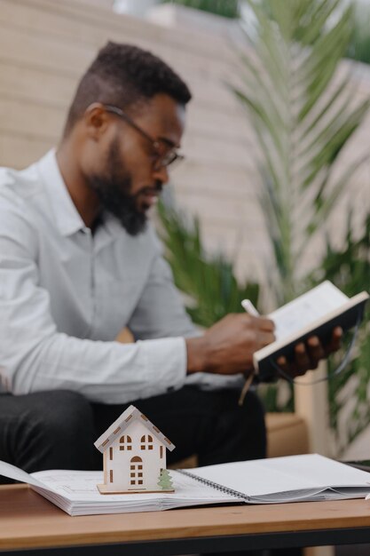 Photo un jeune homme qui utilise un téléphone portable alors qu'il est assis sur une table.