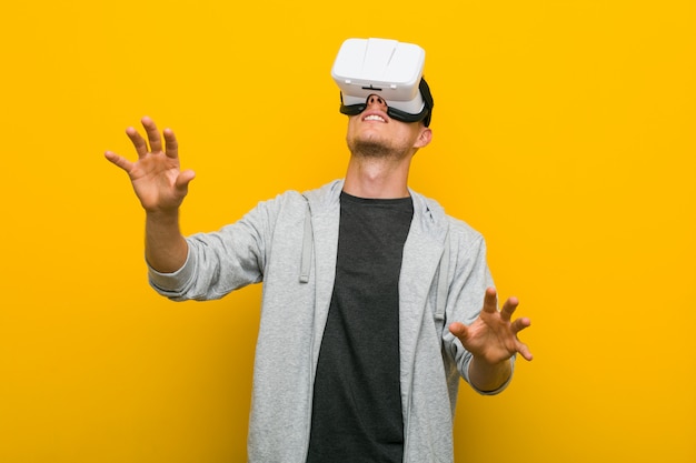 Jeune homme de race blanche à l'aide de lunettes de réalité virtuelle