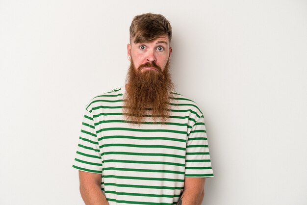 Jeune homme de race blanche au gingembre avec une longue barbe isolé sur fond blanc, visage triste et sérieux, se sentant misérable et mécontent.