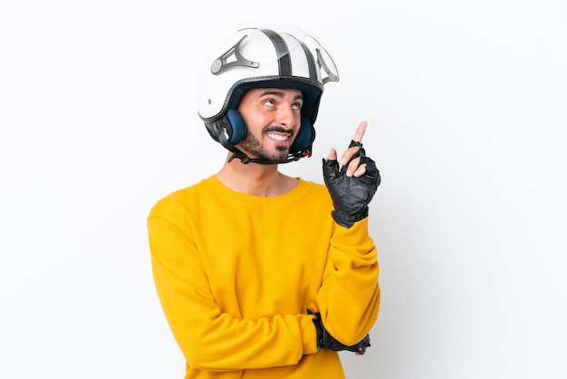 Jeune homme de race blanche avec un casque de moto isolé sur fond blanc pointant vers une excellente idée