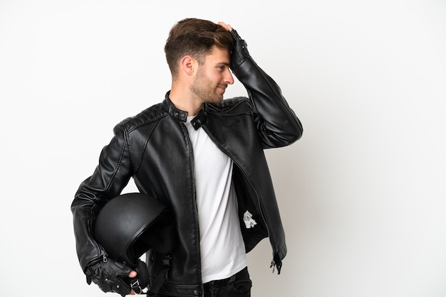 Un jeune homme de race blanche avec un casque de moto isolé sur fond blanc a réalisé quelque chose et envisage la solution