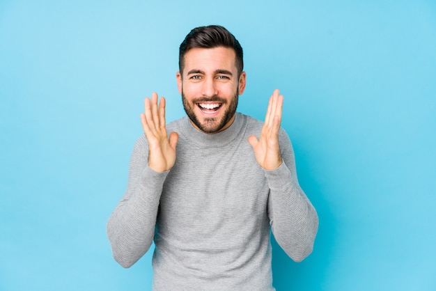 Jeune homme de race blanche contre un mur bleu isolé joyeux rire beaucoup. Concept de bonheur.