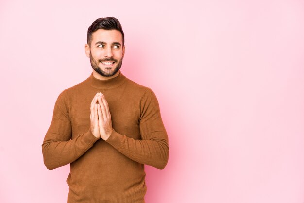 Jeune homme de race blanche contre un mur rose isolé plan de préparation à l'esprit, la mise en place d'une idée.