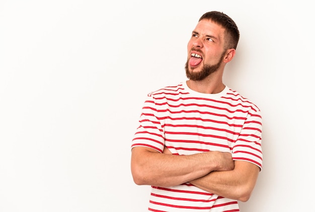 Jeune homme de race blanche avec diastème isolé sur fond blanc drôle et sympathique qui sort la langue.