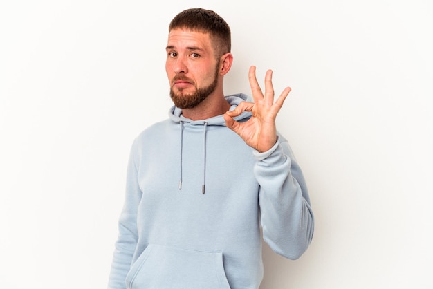 Jeune homme de race blanche avec diastème isolé sur fond blanc fait un clin d'œil et tient un geste correct avec la main.