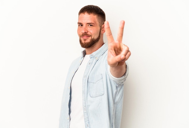 Jeune homme de race blanche avec diastème isolé sur fond blanc joyeux et insouciant montrant un symbole de paix avec les doigts.