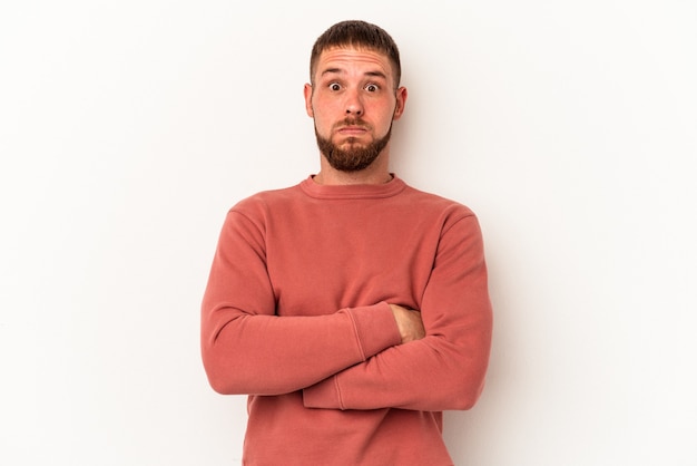 Jeune homme de race blanche avec diastème isolé sur fond blanc souffle les joues, a une expression fatiguée. Concept d'expression faciale.