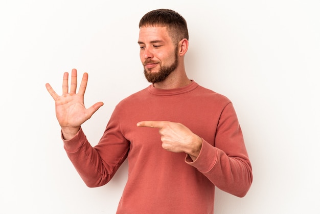 Jeune homme de race blanche avec diastème isolé sur fond blanc souriant joyeux montrant le numéro cinq avec les doigts.