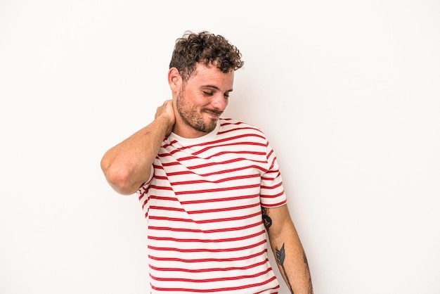 Jeune homme de race blanche isolé sur fond blanc ayant une douleur au cou due au stress, en le massant et en le touchant avec la main.