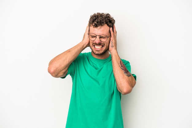 Jeune homme de race blanche isolé sur fond blanc couvrant les oreilles avec les mains.