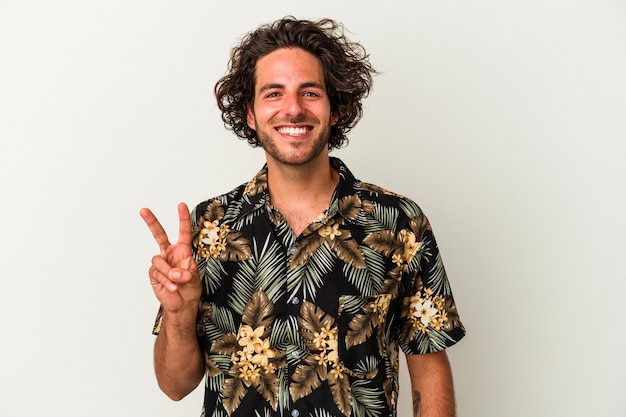 Jeune homme de race blanche isolé sur fond blanc montrant le signe de la victoire et souriant largement.