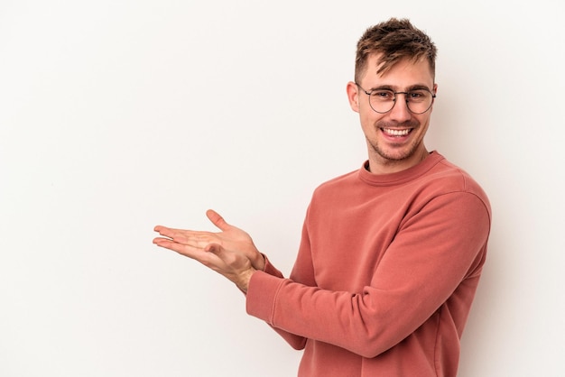 Jeune homme de race blanche isolé sur fond blanc tenant un espace de copie sur une paume.