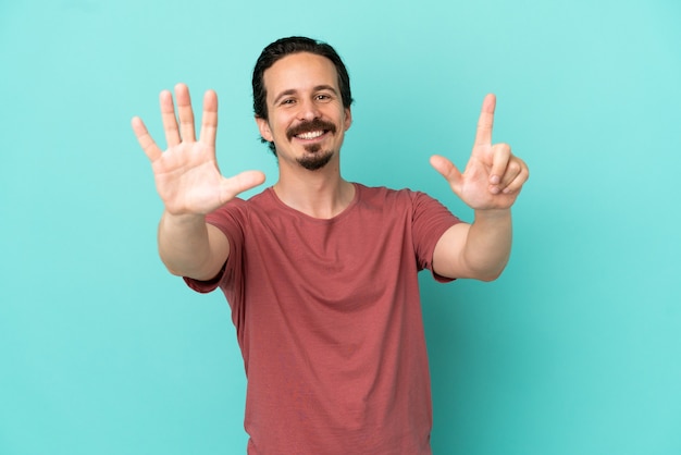 Photo jeune homme de race blanche isolé sur fond bleu comptant sept avec les doigts